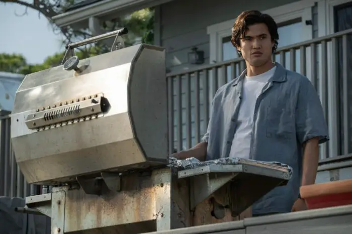 Joe stands on his balcony, cooking on the BBQ as he looks down.