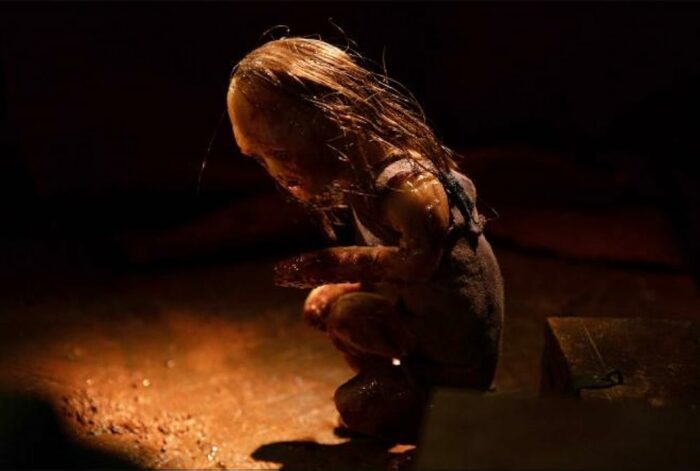 The puppet of the little girl in Stopmotion, slowly turning towards the camera.