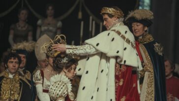 Soon after being coronated emperor of France, a regally adorned Napoleon (Joaquin Phoenix) crowns his queen, Josephine (Vanessa Kirby), as she kneels wearing her own regalia.