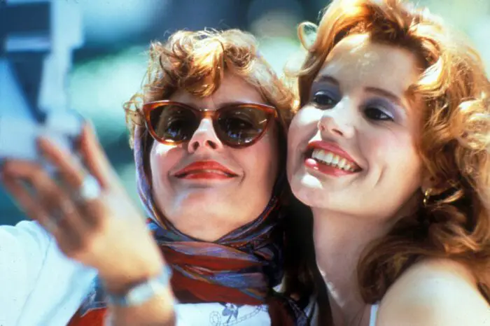 Susan Sarandon and GHeena Davis smile as they pose for a Polaroid selfie in Thelma a& Louise.