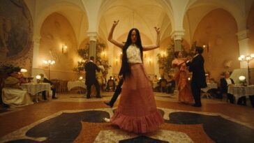 Bella dances in a ballroom without any fear in awkward movements.