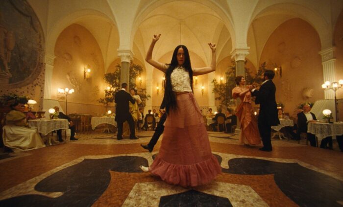 Bella dances in a ballroom without any fear in awkward movements. 