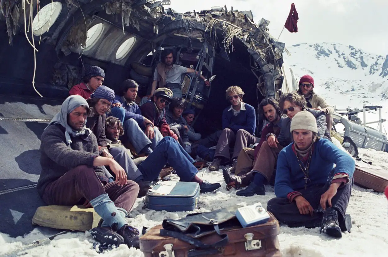 Survivors gather for a photo at a plane crash site in Society of the Snow