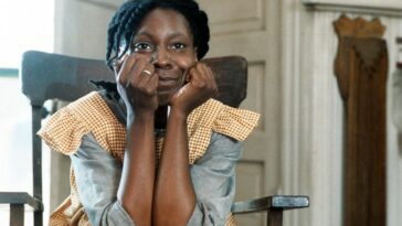 A woman sists in a rocking chair with her head in her hands in The Color Purple