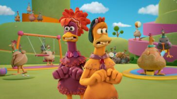 Frizzle and Molly voiced by Bella Ramsey and Josie Sedgwick-Davies in Chicken Run: Dawn of the Nugget (2023). Courtesy of Netflix. Chickens standing around looking terrified by the unsettling yet misleadingly idyllic Fun-Land Farms.