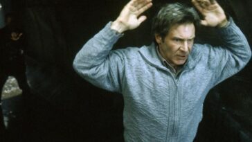 A man at gunpoint puts his hands up in The Fugitive
