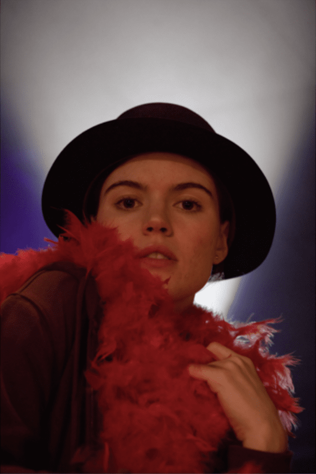 Anwen O'Driscoll as Grace Mitchum in This Time, in a hat and feather boa to look like Liza Minnelli