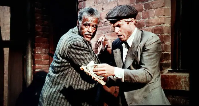 Robert Earl Jones and Robert Redford as Luther and Johnny Hooker in The Sting (1973). An elderly African American man and a young white man stand in an alley amazed by the large money stack they inadvertently conned from someone. Screen capture off the Universal 100th Anniversary Collectors' Series Blu-ray. 