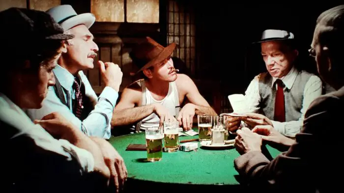 [L to R] Rober Redford, Harold Gould, Paul Newman, Ray Walston, and John Heffernan as Hooker, Kid Twist, Gondorff, J. J. Singleton, and Eddie Niles in The Sting (1973). Five men dressed in 1930s outfits playing poker, drinking beer, and smoking. Screen capture off of the Universal 100th Anniversary Collectors' Series Blu-ray.