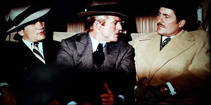 [L to R] Charles Dierkop, Robert Redford, Robert Shaw as Floyd, Johnny Hooker, and Doyle Lonnegan in The Sting (1973). Three men crammed tightly into the back of a 1930s luxury car. Screen capture off the Universal 100th Anniversary Collectors' Series Blu-ray.