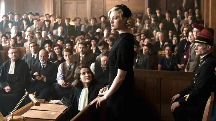 Madeleine (Nadia Tereszkiewicz) addresses the court as Pauline (Rebecca Marder) watches in THE CRIME IS MINE. Courtesy of Music Box Films.