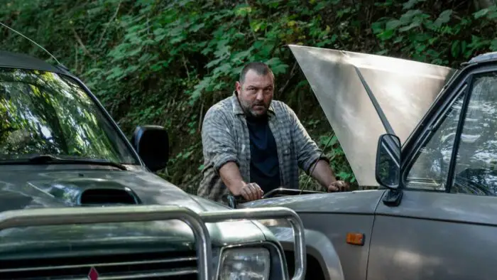 Antoine (Denis Ménochet) stares over an open car hood in The Beasts. 