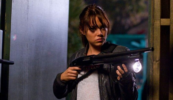Wichita (Emma Stone) wields an automatic rifle.