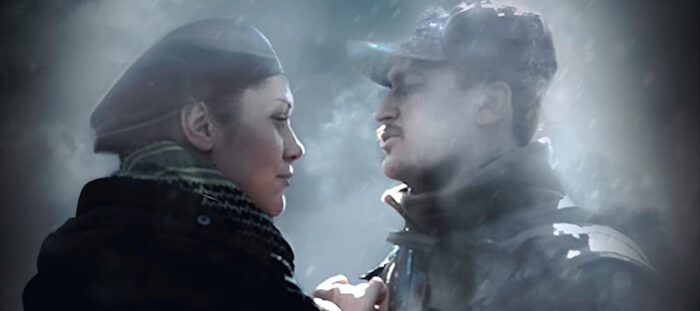 A female Ukrainian volunteer and male soldier face each other as mist rises from the cold of their breath. 