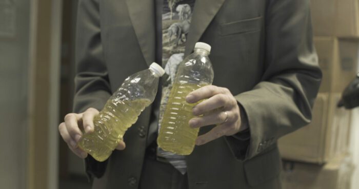 Marc Edwards holds water bottles containing samples of Flint's yellow tap water.
