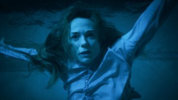 Kerry Condon as Eve Waller in Night Swim, directed by Bryce McGuire. © 2023 Universal Studios. All Rights Reserved. Eve Waller floating underwater, fully clothed, staring in disbelief.