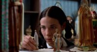 Teresa (Lili Taylor) plays with figurines in Household Saints.