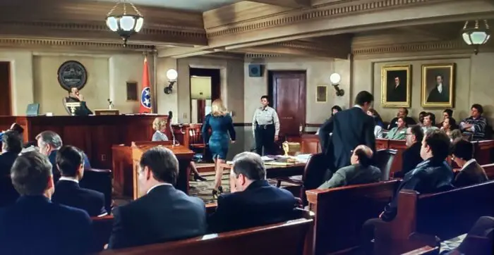 A courtroom filled with people and lawyers is seen in The Rainmaker.