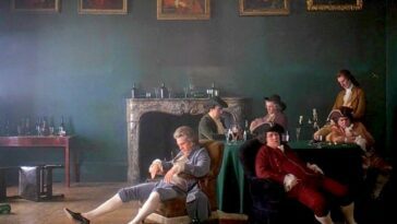 A scene from film Barry Lyndon showing the main character reclining in a chair surrounded by some men.