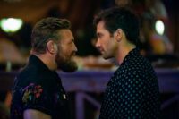 [L to R] Conor McGregor and Jake Gyllenhaal as Knox and Dalton in Road House (2024). Amazon MGM Studios. Bearded Knox attempting to stare down the zen like Dalton in a dive bar as the two get ready to fight.