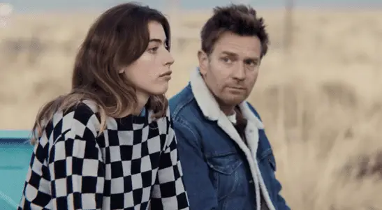 Clara McGregor and Ewan McGregor as Daughter and Father in Bleeding Love (2023). Image courtesy of R&CPMK. Father and Daughter lean against a pickup truck in the desert, staring off wistfully.