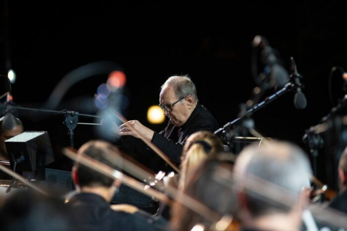 Ennio Morricone conduct an orchestra.