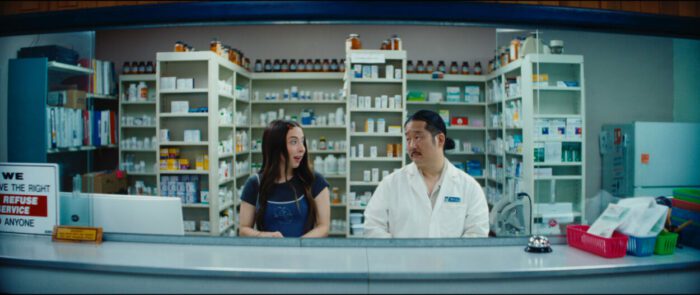 June and her boss stand behind the counter at the pharmacy
