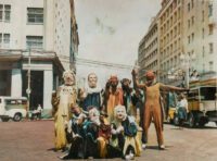 A group of people pose in costumes on the streets of Recife.