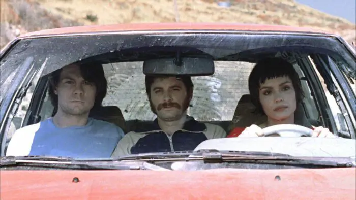 The core cast of the film Wristcutters: A Love Story in the beat up car they spend much of the film in. None are smiling, the car is clearly dirty, not being taken care of properly in some time.