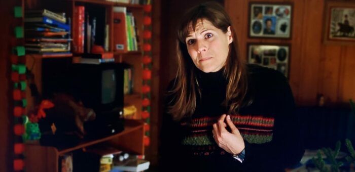 Mary McCormack as Donna Biebe in Mystery, Alaska (1999). Screen capture off Amazon. Hollywood Pictures/Buena Vista Pictures Distribution. Housewife at home straining to make her husband understand she feels unappreciated.