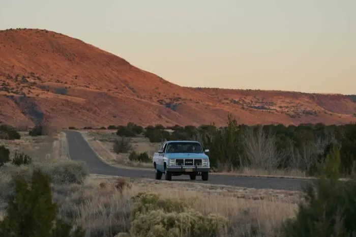 Pickup truck driving through the desert in Bleeding Love (2023). Image courtesy of R&CPMK. 