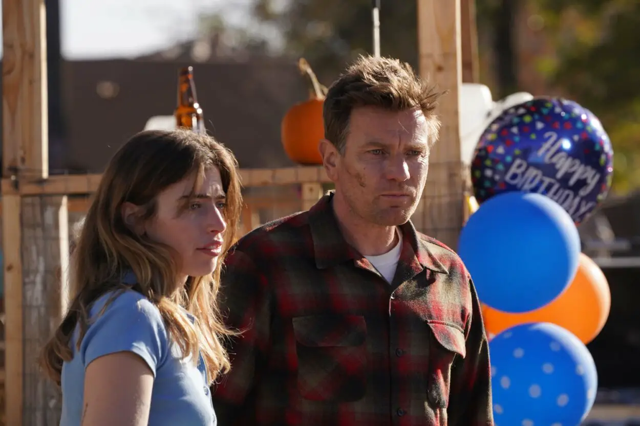 Clara McGregor and Ewan McGregor as Daughter and Father in Bleeding Love (2023). Image courtesy of R&CPMK. Daughter and Father at a backyard birthday party, balloons hanging nearby.