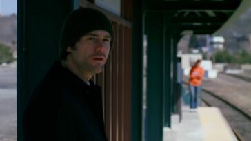 Joel waits on a train platform as Clementine watches in Eternal Sunshine of the Spotless Mind