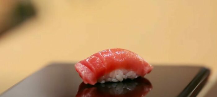 A piece of sushi on a plate.