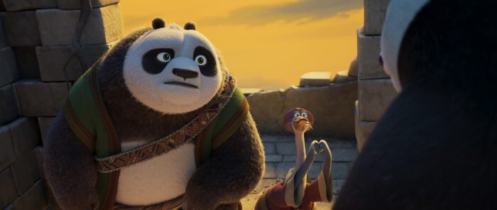 A panda father stands next to a goose making a heart sign in Kung Fu Panda 4.