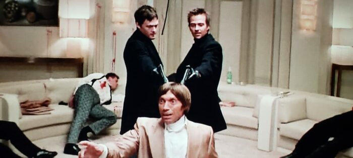 Norman Reedus, Sean Patrick Flannery, and Viktor Pedtchenko as Murphy, Connor, and Yuri Petrov in The Boondock Saints (1999). Screen capture off of DVD. Franchise Pictures. Russian mob boss Yuri is on his knees while black clad Connor and Murphy hold silenced pistols to the back of his head.