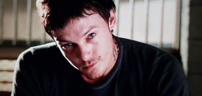 Norman Reedus as Murphy MacManus in The Boondock Saints (1999). Screen capture off of DVD. Franchise Pictures. Murphy MacManus sits in a jail cell smoldering as he ponders the future.