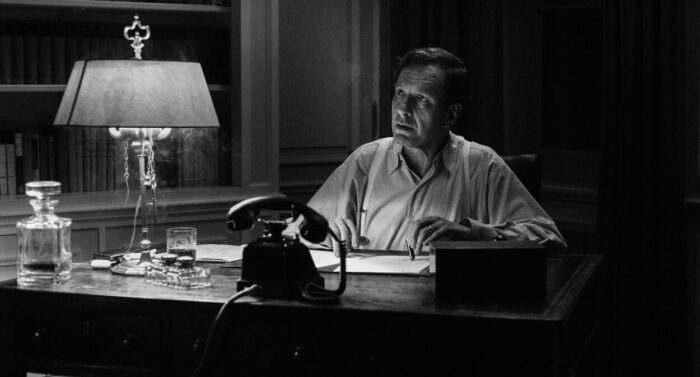 Michael Neuenschwander as Heinreich Zwygart in A Forgotten Man (2022). Sovereign Films. Black and white scene of Zwygart at his desk looking harried as the weight of his choices crushes him psychologically.