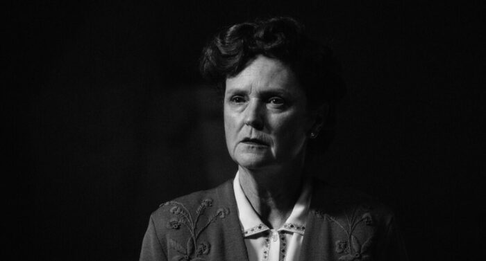 Manuela BIedermann as Clara Zwygart in A Forgotten Man (2022) Sovereign Films. Black and white scene of Swiss housewife Clara standing alone looking increasingly dismayed and confused.