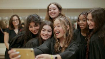 A group of teen girls in Supreme Court robes pose for a selfie