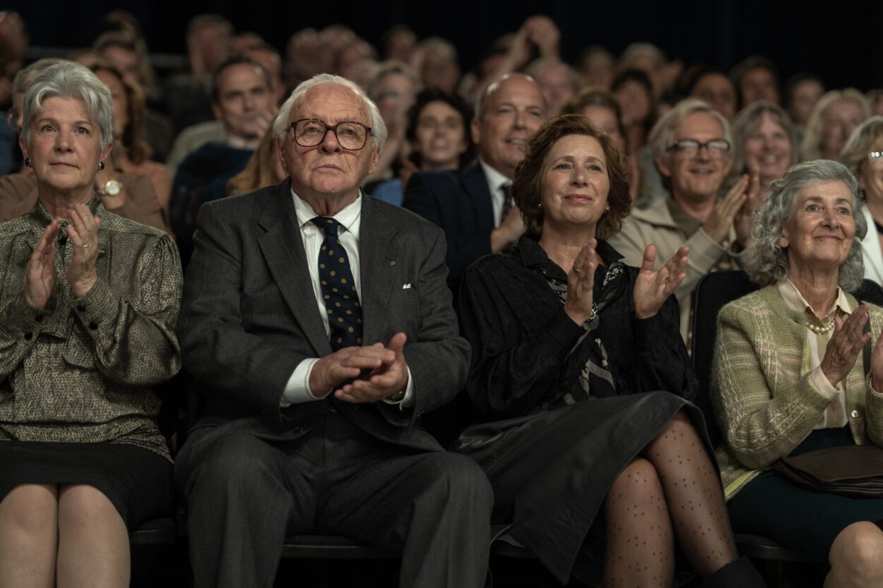 An elderly man in glasses sits in a TV studio audience in One Life.