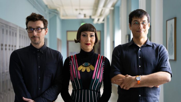 Toto, Yvonne, and Josh of The Octopus Project stand in a hallway