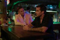 Two men talk at a bar in Road House.