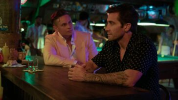 Two men talk at a bar in Road House.