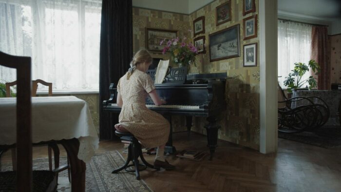 A young girl plays Joseph Wulf's "Sunbeams" on the piano.