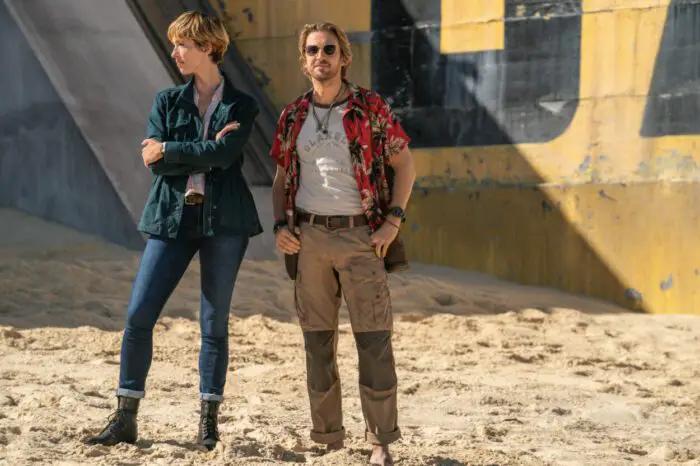 Dr. Ilene Andrews (Rebecca Hall) and Trapper (Dan Stevens) stand outside in the sun at a Monarch base.