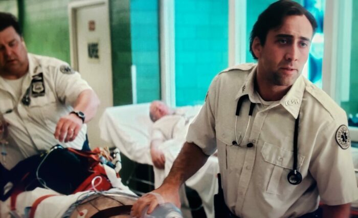 Nicolas Cage and John Goodman as Frank and Larry in BRINGING OUT THE DEAD (1999). Screen capture off of Amazon. Paramount Pictures. Larry and Frank bringing a patient into the ER.