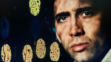 Nicolas Cage as Frank Pierce in BRINGING OUT THE DEAD (1999). Screen capture off of Amazon. Paramount Pictures. Frank sitting in the ambulance, closeup on his face as rain drops on the window artistically glow in streetlamp light.