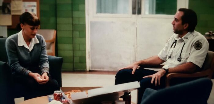 Nicolas Cage and Patricia Arquette as Frank and Mary in BRINGING OUT THE DEAD (1999). Screen capture off of Amazon. Paramount Pictures. Mary and Frank share a pizza in the waiting room of a hospital while waiting for word about Mary's father, a dying patient.