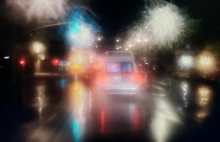 Street scene from BRINGING OUT THE DEAD (1999). Screen capture off of Amazon. Paramount Pictures. Cinematically blurred shot of an ambulance racing through city streets.
